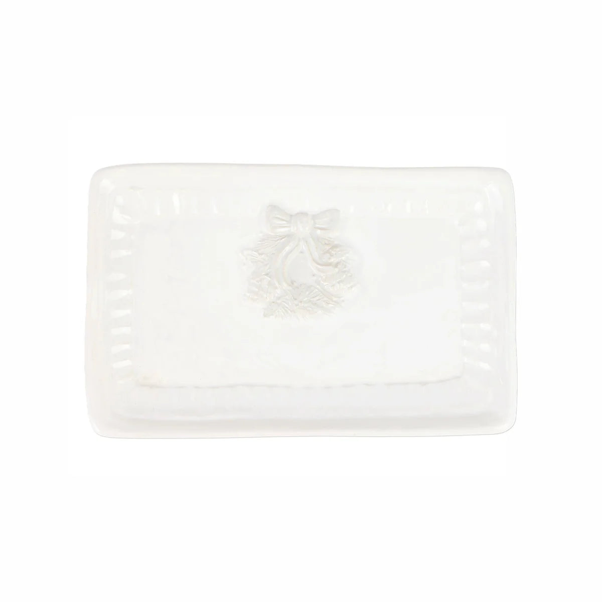 A white rectangular ceramic dish with a raised central bow and wreath motif, photographed on a clean white background.